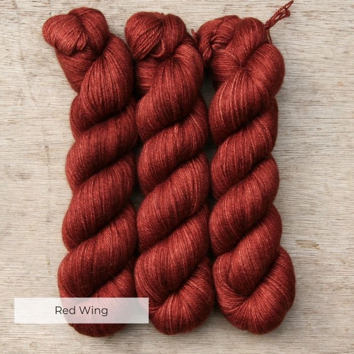 Three skeins of soft yarn in deep red