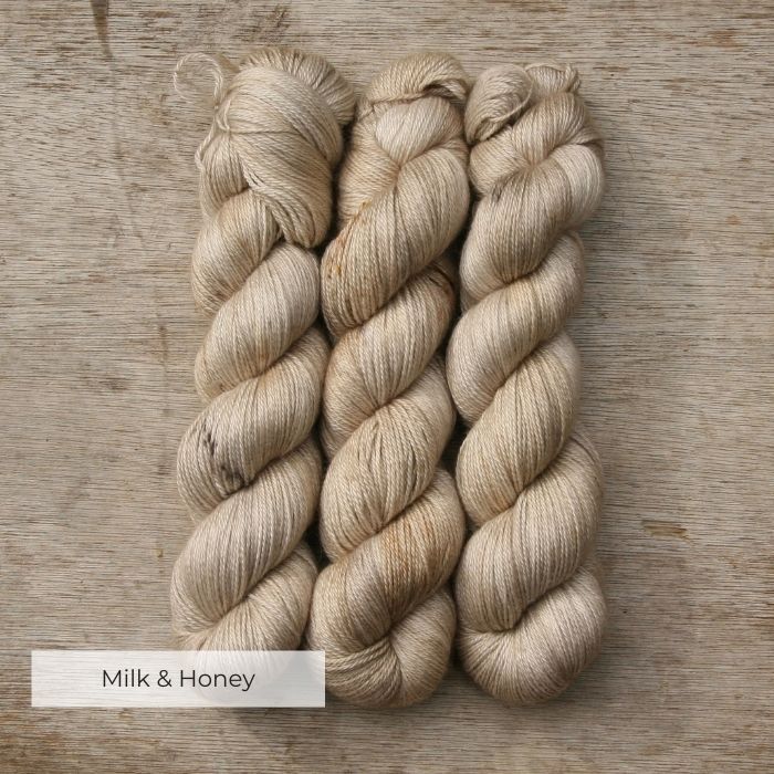 Three skeins of soft alpaca and silk yarn in cream, pale gold and brown