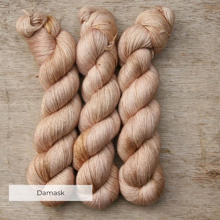 Three skeins of yarn the colour of whitewashed terracotta