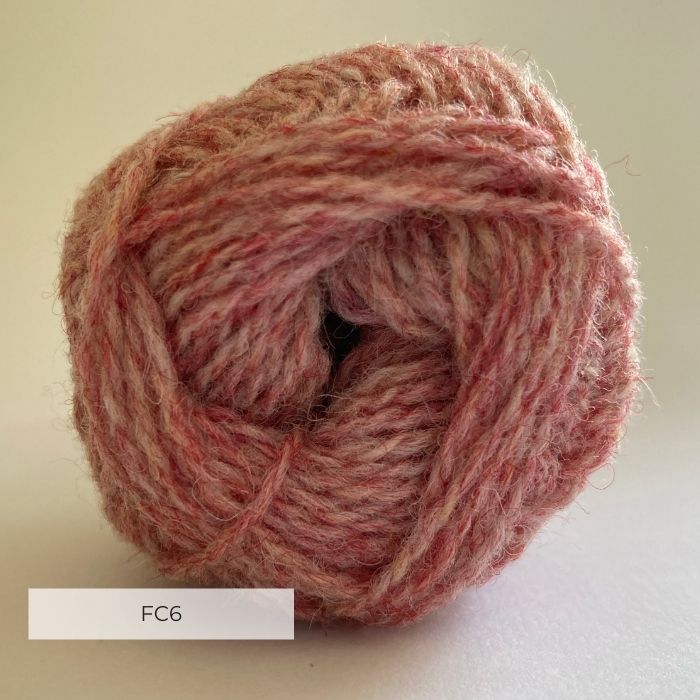 Close up of the end of a ball of wool in a soft marled pink