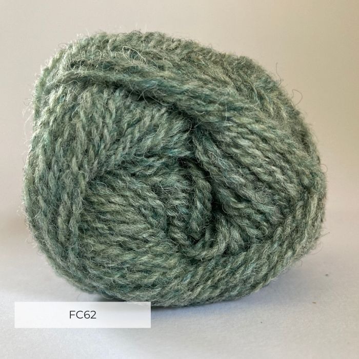 Close up of the end of a ball of wool in a light grey green