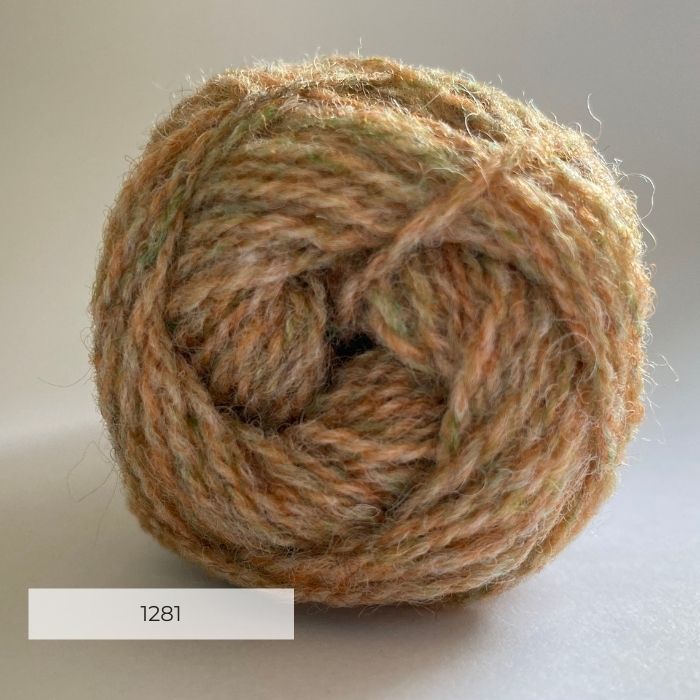Close up of the end of a ball of wool in a soft marled peach and green