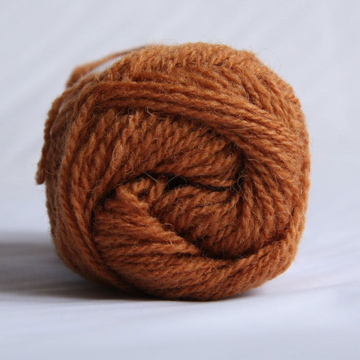 The end of a single ball of shetland wool in an amber colour