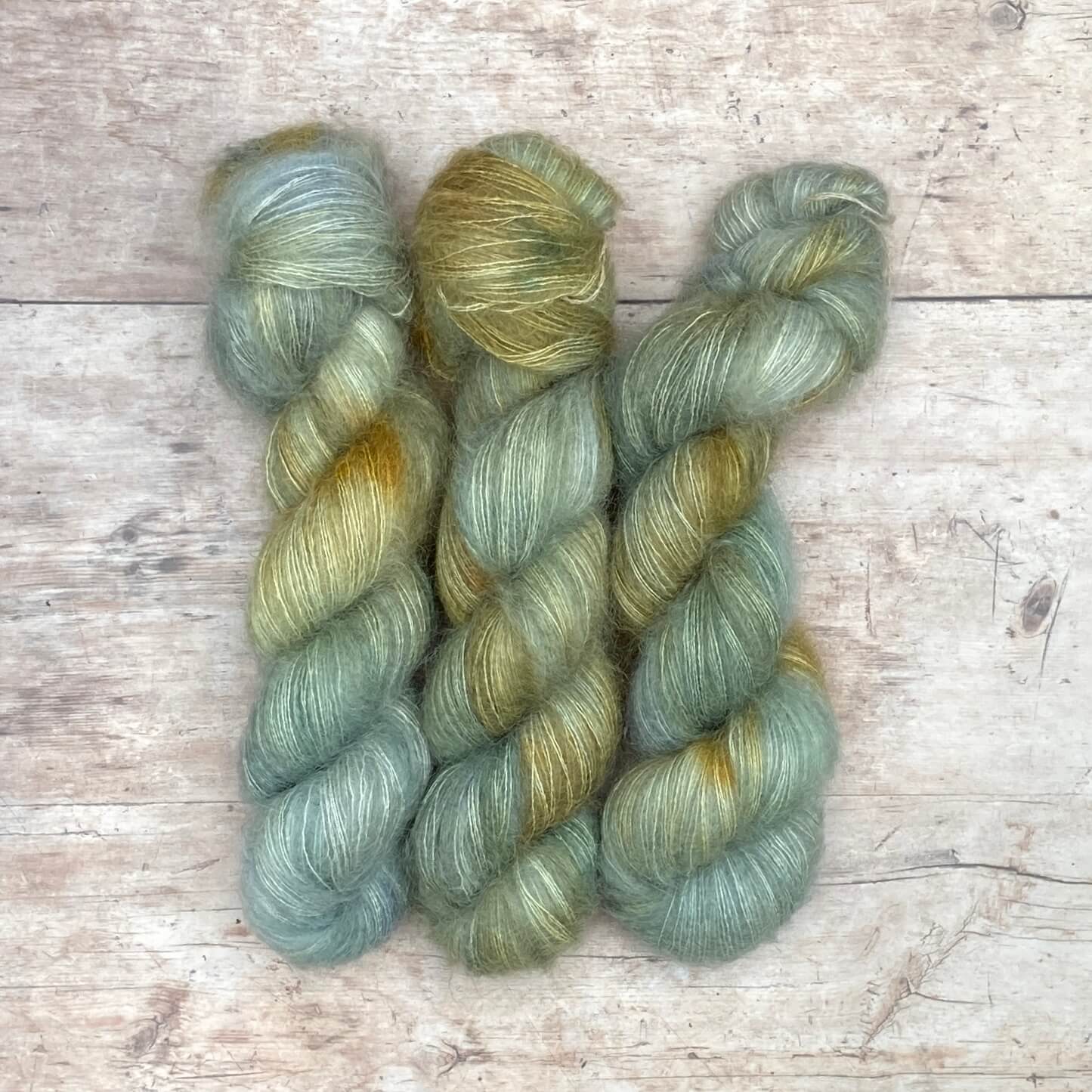 Three skeins of Mohair Lace in watery shades of blue and green with splashes of golden yellow