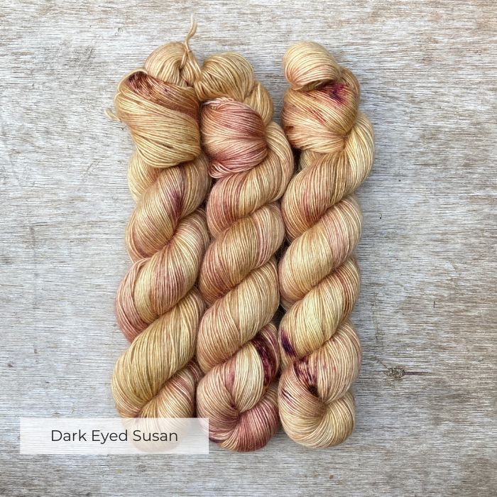 Golden, creamy yellow yarn splashed with orange and pink and wound into skeins