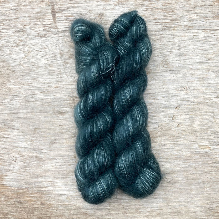 Two skeins of fluffy mohair in a dark grey teal