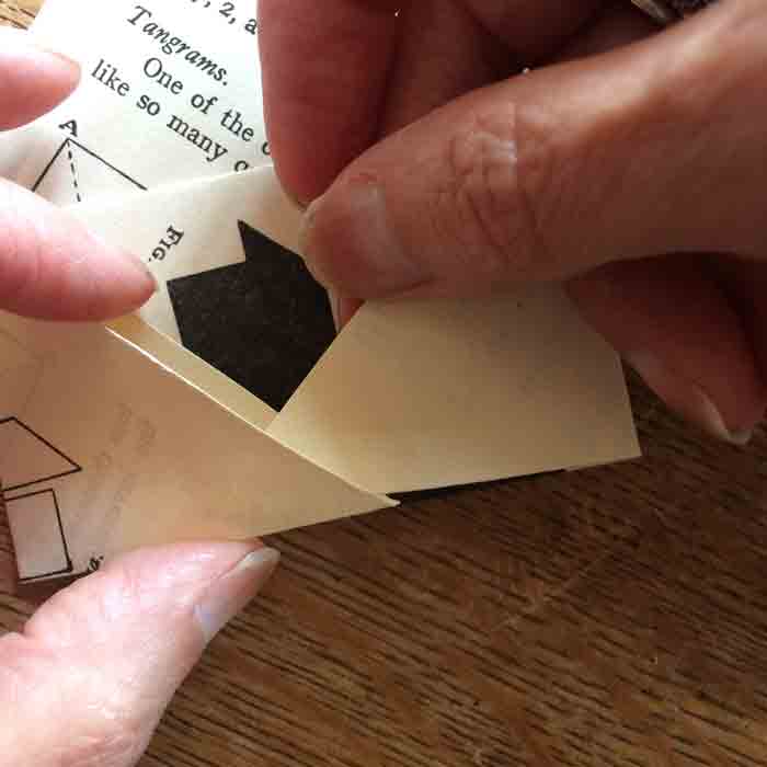A pair of hands tucking in the corners of a paper envelope