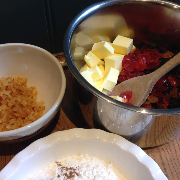 A saucepan with cubes of butter and cherries, a dish of flour and spice and a bowl of Satan's toenails