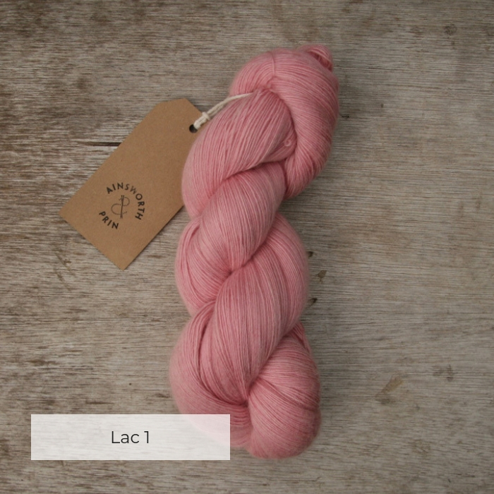 A single skein of pink yarn with a brown tie tag