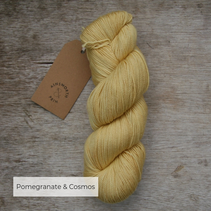 A single skein of soft yellow yarn with a brown tie tag