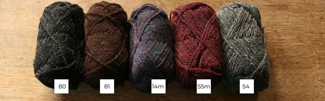 Five balls of Shetland wool lined up in a row from light to dark