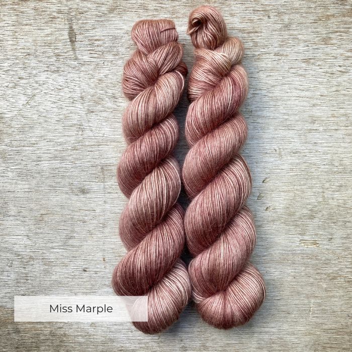 To skeins of soft lightly fluffy yarn in a deep crushed pink