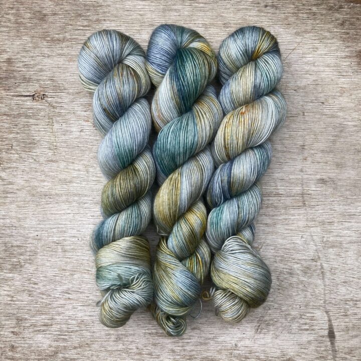 Three skeins of a pale blue green with splashes of yellow