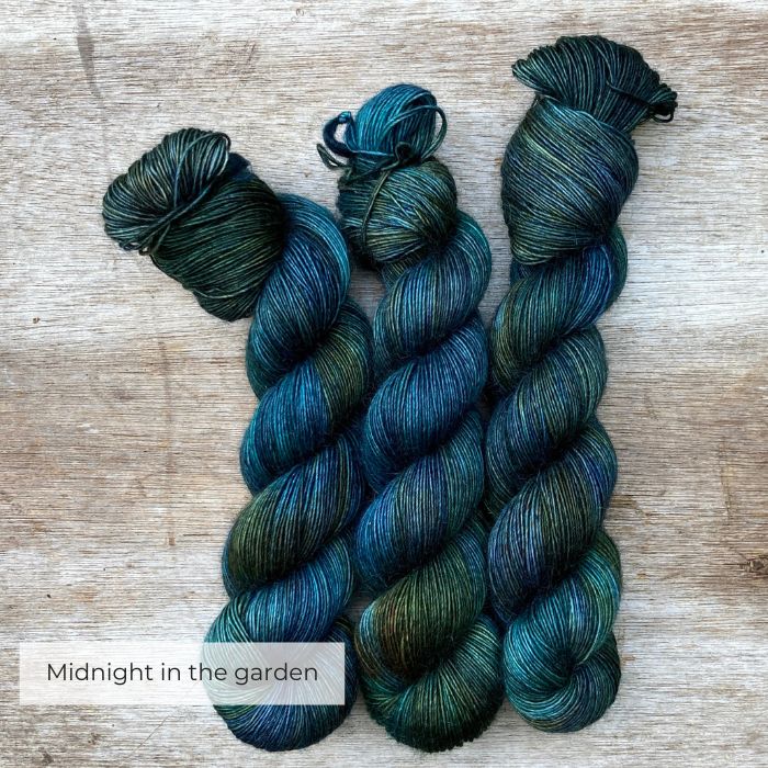There skeins of softly fluffy yarn in shades of dark blue, green and teal