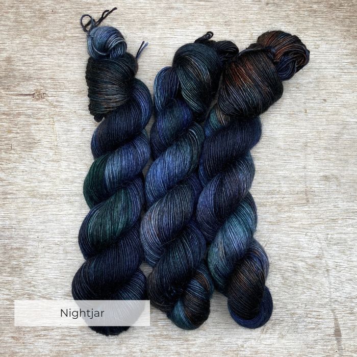 Three skeins of merino and mohair in deep greens, inky blues and rust