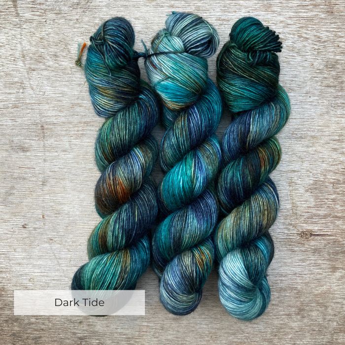 skeins of yarn dyed with splashes of navy, emerald and gold