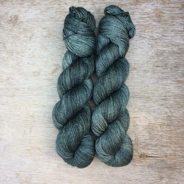 Two skeins of yarn in dark petrol blue green