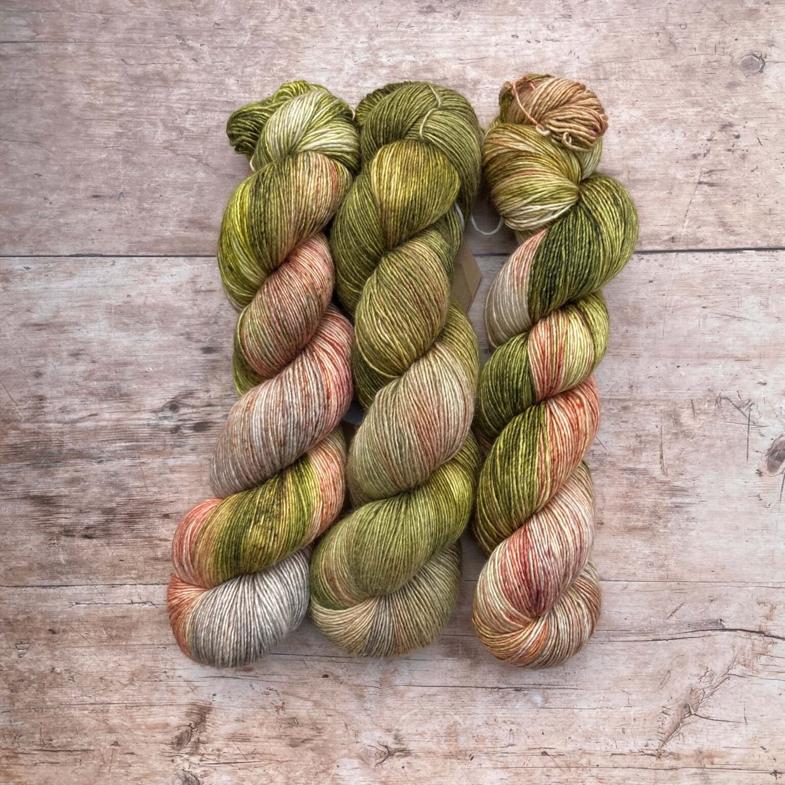 Three skeins of Merino & Silk in green, pink and soft grey