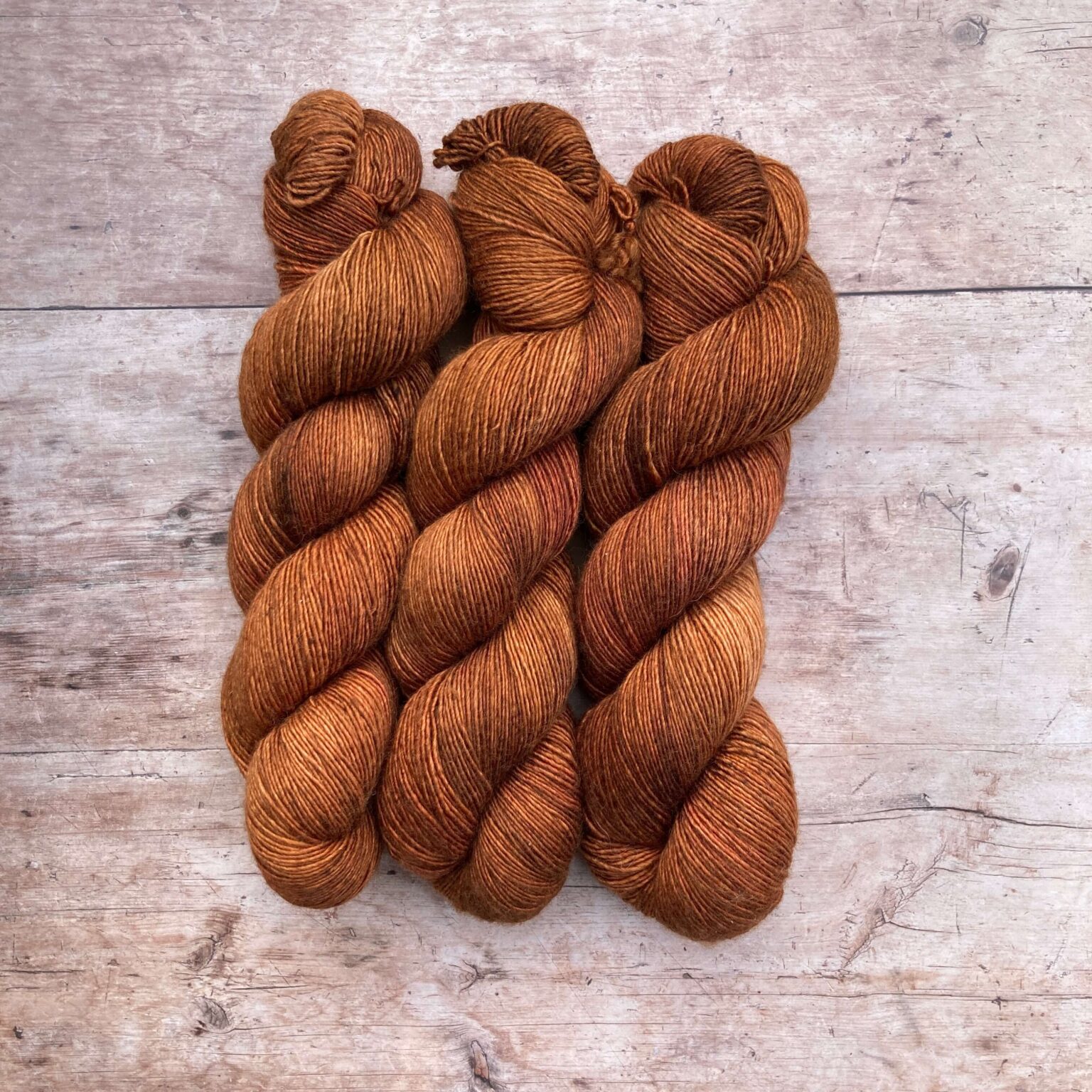 Three skeins of Merino Silk in a rich ginger with pink overtones