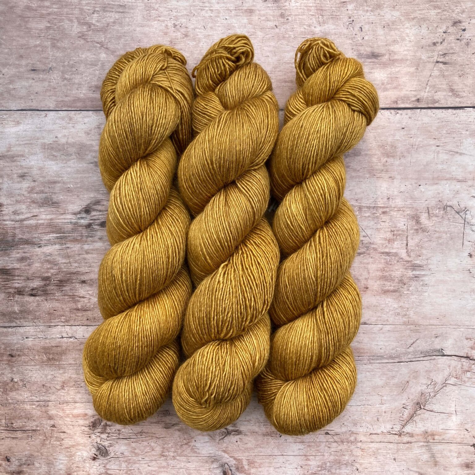 Three skeins of Merino Silk in a rich golden yellow