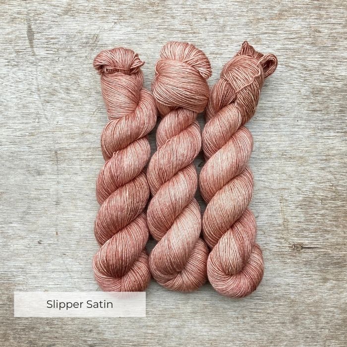 Three skeins of a soft peachy pink silky yarn