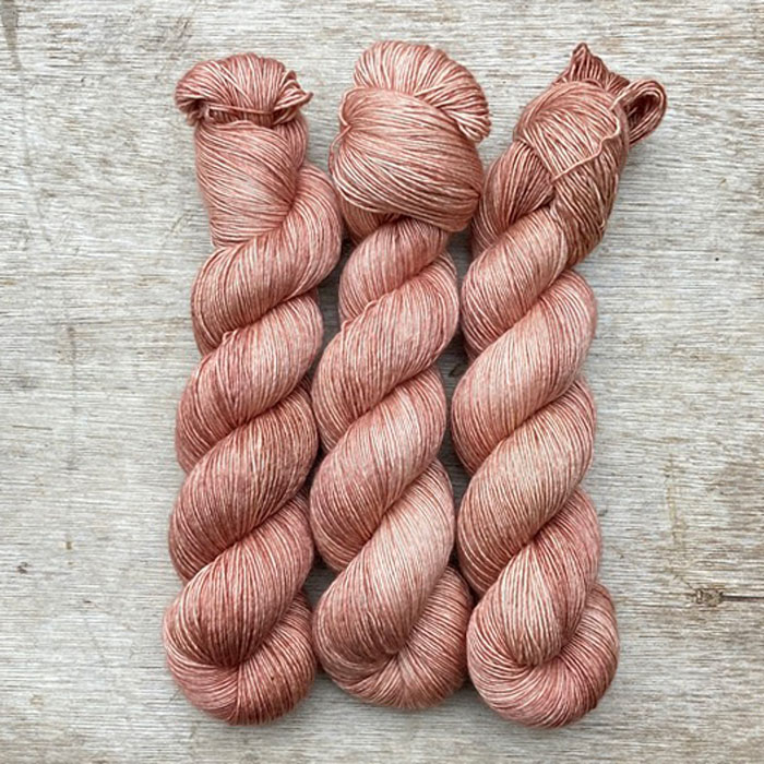 Three skeins of a soft peachy pink silky yarn