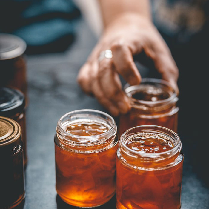 Three jars of glowing marmalade on a grey work surface