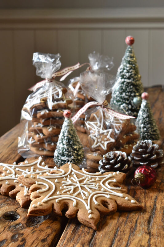 Christmas gingerbread in clear gift bags on a wood surface with Christmas decorations