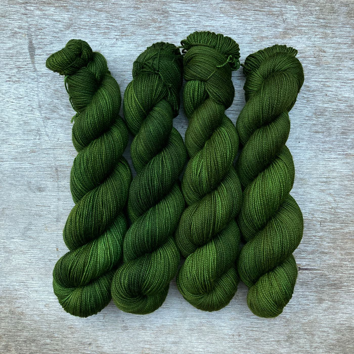 Four skeins of dark grass green yarn