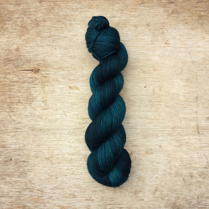 A semi solid skein of green blue yarn