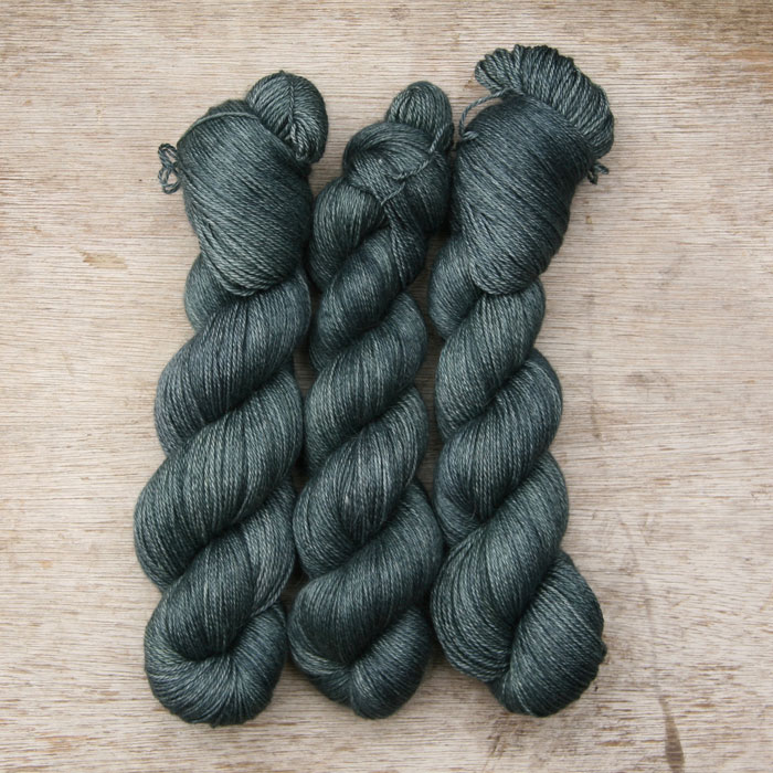 Three skeins of soft alpaca yarn the colour of the deep sea