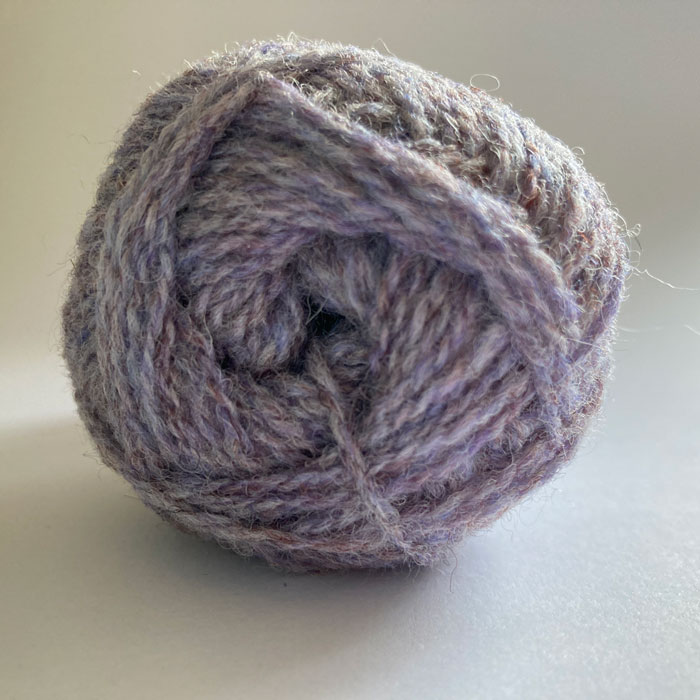 Close up of the end of a ball of wool in a soft marled lilac