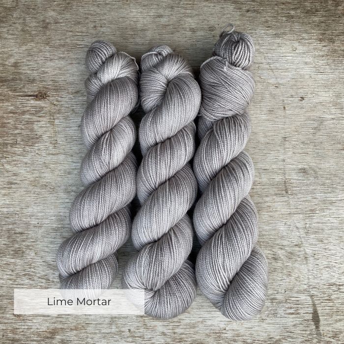 Three soft skeins of pale grey yarn