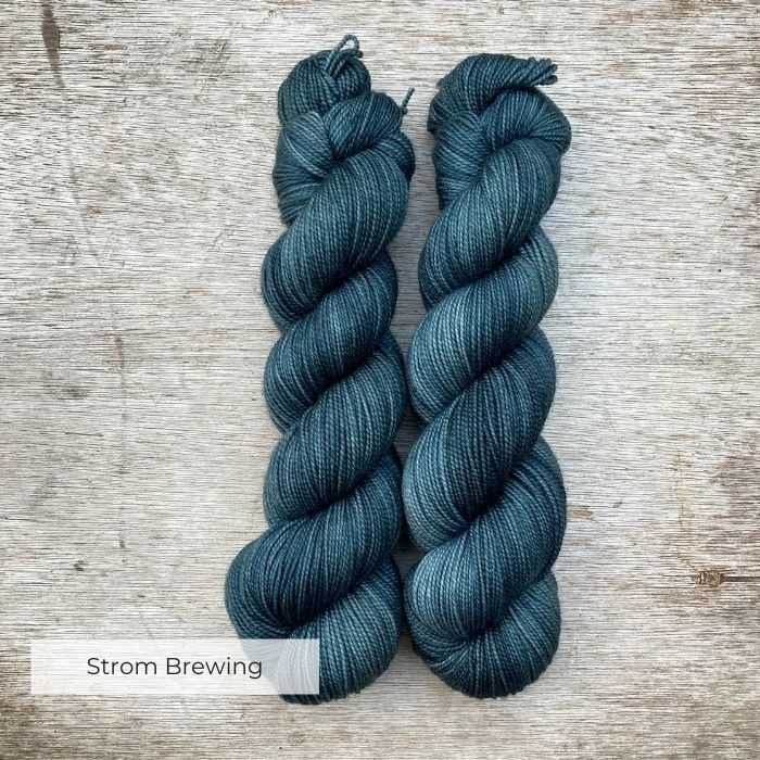 Two skeins of yarn in dark petrol blue green