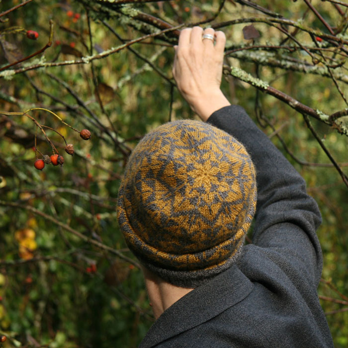 A close up of the top of a knitted hat showing the star pattern in the colour work