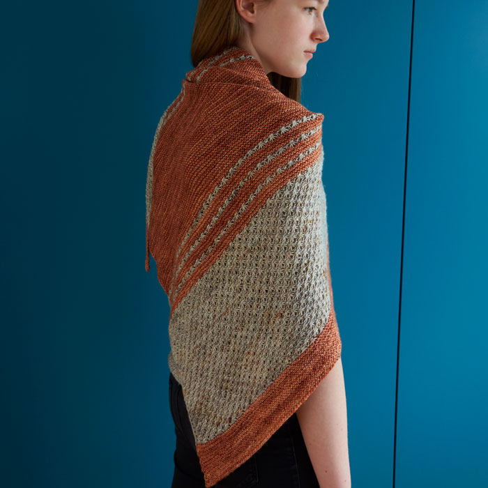 A girl wearing a terracotta and cream shawl