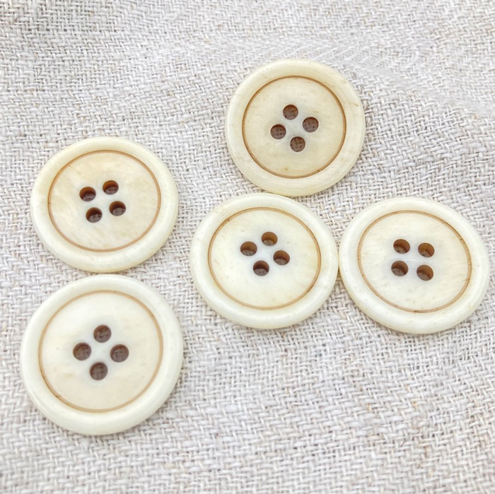 Five cream buttons on a cloth