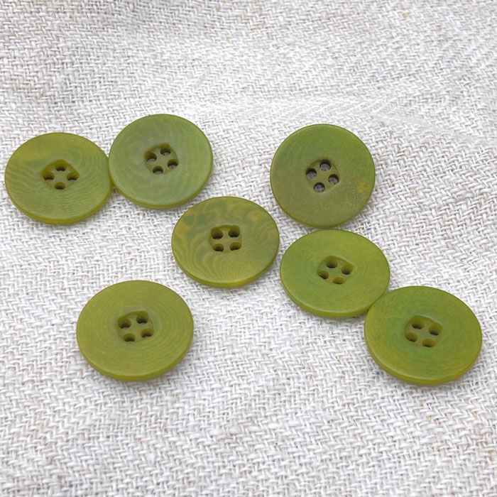 Green buttons on a linen background