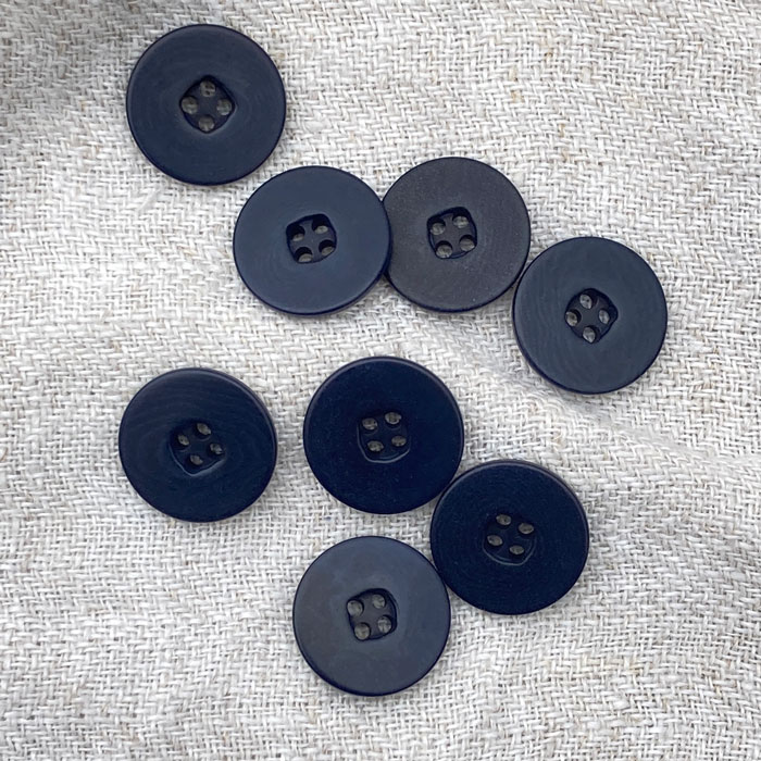 Navy buttons on a linen background