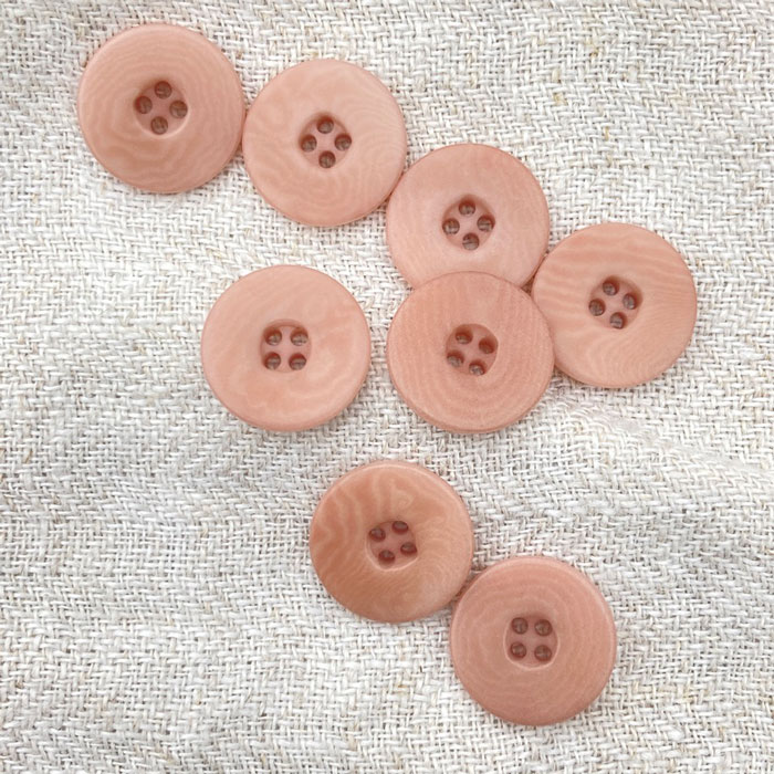 Pink buttons on a linen background