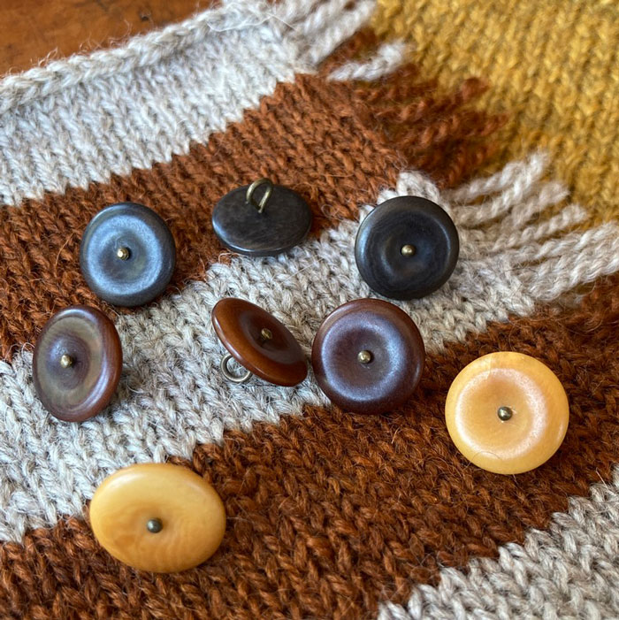 Mixed buttons on a knitted, striped background