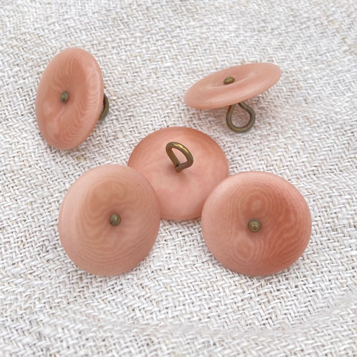Five pink buttons with a bronze metal shank
