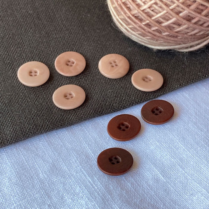 Flat, matt, four hold buttons on a linen background