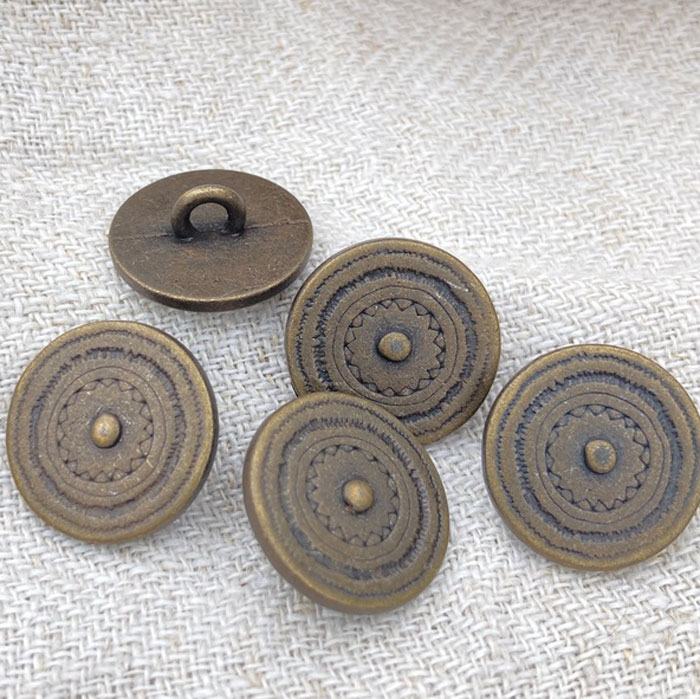 Five bronze coloured metal shank buttons