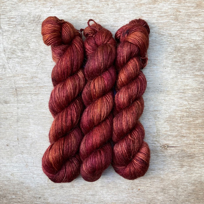 Three skeins of yarn a golden burgundy colour