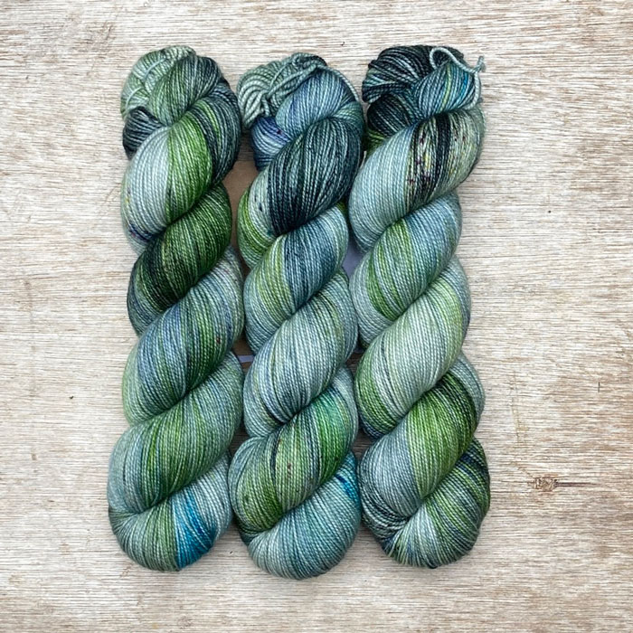 Three skeins of yarn in light blue, emerald and ink