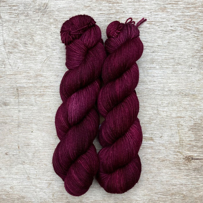 Two skeins of dark pink red wool