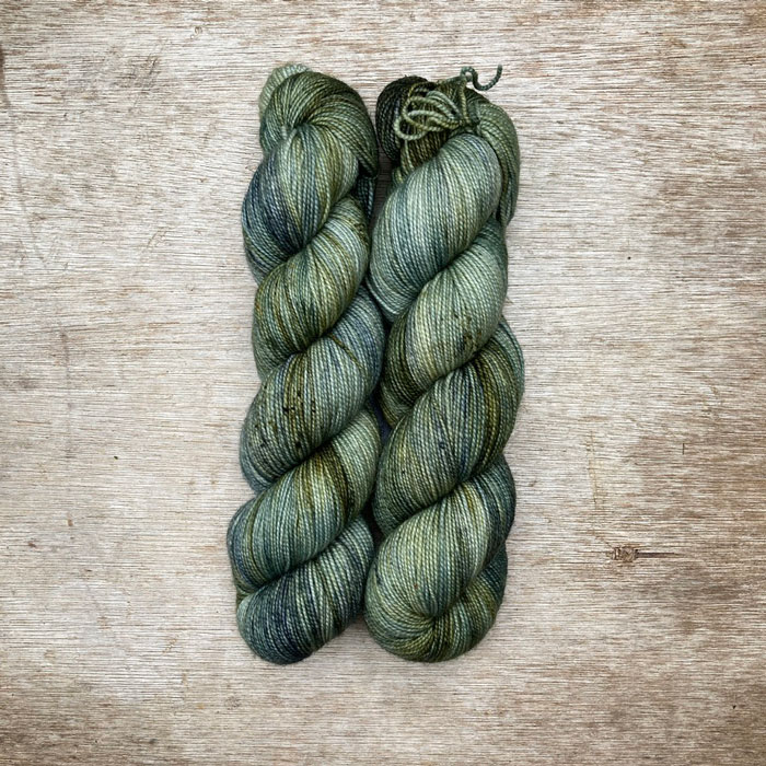 Two skeins of yarn in shades of blue and dark olive green