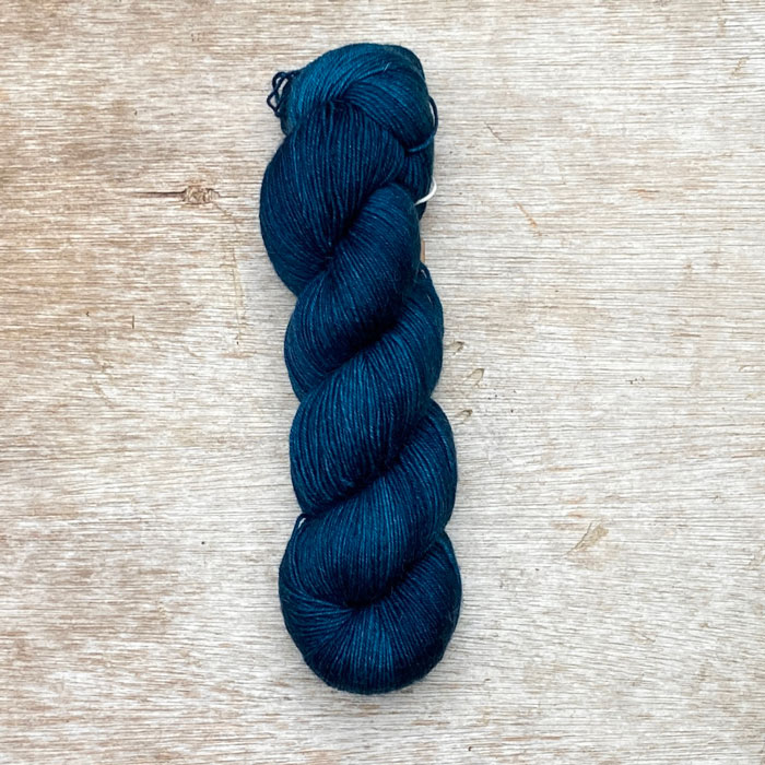 A single skein of deep teal yarn