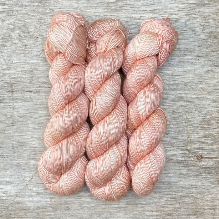 Three skeins of the softest pink with faint yellow speckles